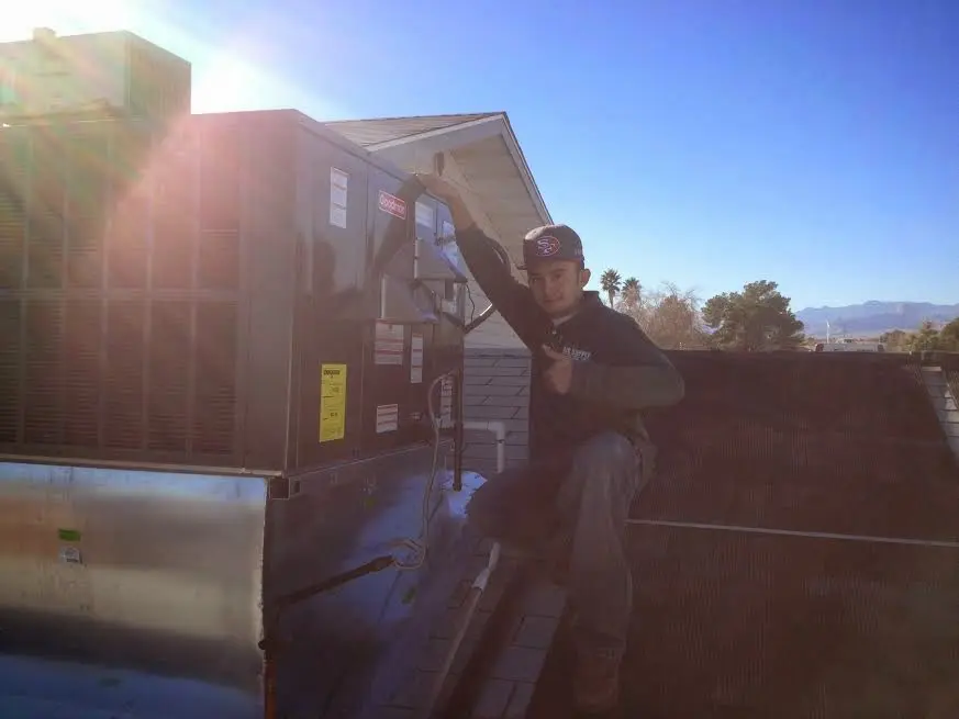 HVAC technician performing AC Tune-Up on a rooftop unit in Hornsby Bend